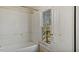 Vintage-style bathroom featuring a tub with shower, and a large bright window at 404 Cherry St, Oxford, NC 27565