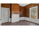 Living room with natural light, wood paneled walls, fireplace, and classic molding details at 404 Cherry St, Oxford, NC 27565