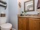 Bathroom with wood vanity, granite countertop, mirror, toilet, and linen storage at 4617 Atterbury Ct, Raleigh, NC 27604