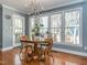 Dining room featuring a wood table, three windows providing ample natural light and hardwood floors at 4617 Atterbury Ct, Raleigh, NC 27604