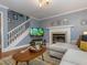 Cozy living area with a fireplace, staircase, and comfortable seating, offering a relaxing and inviting atmosphere at 4617 Atterbury Ct, Raleigh, NC 27604