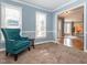 Inviting living room featuring neutral tones, a plush teal armchair, and natural light at 4617 Atterbury Ct, Raleigh, NC 27604
