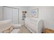 Bright Bedroom featuring a white crib, comfortable chair and closet at 4708 Sweetbriar Dr, Raleigh, NC 27609