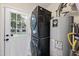 Bright laundry room featuring a stacked washer/dryer set and water heater at 4708 Sweetbriar Dr, Raleigh, NC 27609