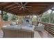 Covered outdoor patio with stone fireplace, mounted television, and comfortable seating at 4708 Sweetbriar Dr, Raleigh, NC 27609