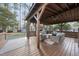 Outdoor covered patio with fireplace, TV, and comfortable seating overlooking a green lawn at 4708 Sweetbriar Dr, Raleigh, NC 27609
