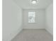A bedroom featuring neutral carpeting and a window that brings in natural light at 4821 Heathshire Dr, Raleigh, NC 27616