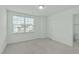 Bedroom with neutral carpeting, a window with blinds, and an attached bathroom at 4821 Heathshire Dr, Raleigh, NC 27616