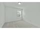 A bedroom with neutral carpeting and a window providing natural light and exterior views at 4821 Heathshire Dr, Raleigh, NC 27616