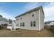 Rear exterior view of the home showcases the deck, patio, fenced yard, and lush grass at 4821 Heathshire Dr, Raleigh, NC 27616
