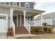 Inviting front porch with white railings, brick stairs, and manicured landscaping at 4821 Heathshire Dr, Raleigh, NC 27616