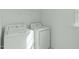 Bright laundry room featuring a white washer and dryer and wire shelving for easy organization at 4821 Heathshire Dr, Raleigh, NC 27616