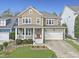 Charming two-story home featuring a welcoming front porch and attached two-car garage at 500 Skygrove Dr, Holly Springs, NC 27540