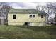 Back of home with yellow siding, a green metal roof, and mature trees at 510 Short W St, Hillsborough, NC 27278