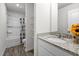 Bright bathroom featuring granite countertops, shower-tub combo, and built-in shelving at 538 E Waycliff Rd, Henderson, NC 27537