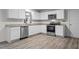 Well-lit kitchen featuring white cabinets, stainless steel appliances, and stone countertops at 538 E Waycliff Rd, Henderson, NC 27537