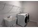 Laundry room with large wash basin, modern washer and dryer and shelving at 548 Jocund St # 15, Rolesville, NC 27571
