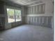 Bright bedroom featuring a large window with a view and freshly finished drywall ready for paint at 564 Jocund St # 11, Rolesville, NC 27571