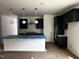 Modern kitchen featuring dark cabinets, a central island, and stainless steel appliances for culinary enthusiasts at 564 Jocund St # 11, Rolesville, NC 27571