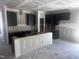 Unfinished modern kitchen with dark cabinets and a large island, great for entertaining and Gathering meals at 564 Jocund St # 11, Rolesville, NC 27571