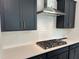 A close-up of the gas range, white subway tile backsplash and vent hood in this modern kitchen at 564 Jocund St # 11, Rolesville, NC 27571