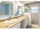Bright bathroom featuring double sinks, granite counters, and tiled shower at 5715 Sky Lane Dr, Durham, NC 27704