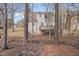 The rear of this home is surrounded by mature trees, with a small stream and deck at 700 Grandview Dr, Durham, NC 27703
