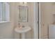 Elegant powder room featuring a pedestal sink, modern mirror, and a bright window at 700 Grandview Dr, Durham, NC 27703