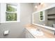 Bright bathroom with updated fixtures, vanity, mirror, and a view to the outside at 716 S Meadow Rd, Raleigh, NC 27603