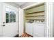 Bright laundry area with washer and dryer, plus convenient access to the outside and shelving at 716 S Meadow Rd, Raleigh, NC 27603