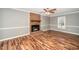 Living room with brick fireplace, wood floors, ceiling fan, and natural light from a window at 716 S Meadow Rd, Raleigh, NC 27603