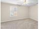 Spacious bedroom featuring neutral carpet, large window, and a ceiling fan at 723 Renshaw Ct, Cary, NC 27518