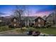 Brick apartment complex with a manicured lawn and ample parking at dusk at 723 Renshaw Ct, Cary, NC 27518