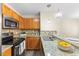 Well-lit kitchen features granite countertops, stainless steel appliances, and wood cabinets at 723 Renshaw Ct, Cary, NC 27518