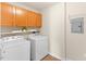 Well-lit laundry room with washer, dryer, and wooden cabinets for ample storage at 723 Renshaw Ct, Cary, NC 27518