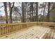 Outdoor deck with wooden railing surrounded by trees, perfect for relaxing and entertaining at 7317 Sandy Creek Dr, Raleigh, NC 27615