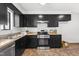 Modern kitchen with black cabinetry, stainless steel appliances, and light countertops at 7317 Sandy Creek Dr, Raleigh, NC 27615