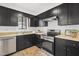 Kitchen featuring black cabinets, stainless steel appliances, and light countertops at 7317 Sandy Creek Dr, Raleigh, NC 27615