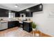 Well-lit kitchen featuring black cabinets, stainless steel appliances, and neutral countertops at 7317 Sandy Creek Dr, Raleigh, NC 27615