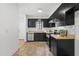 Well-lit kitchen showcasing black cabinets, stainless steel appliances, and tile backsplash at 7317 Sandy Creek Dr, Raleigh, NC 27615