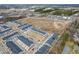 An aerial view captures a community of townhomes near a retail area and undeveloped land at 7802 Flatrock Park Dr # 131, Knightdale, NC 27545