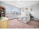 Light-filled bedroom with three windows, a charming bedspread, and coordinated decor creates a cozy retreat at 7802 Flatrock Park Dr # 131, Knightdale, NC 27545