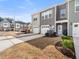 Townhome exterior with garage, patio, and landscaping showcases modern design and curb appeal, under a blue sky at 7802 Flatrock Park Dr # 131, Knightdale, NC 27545