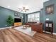 Cozy living room with wood floors, a ceiling fan, large window, and a stylish entertainment center at 7802 Flatrock Park Dr # 131, Knightdale, NC 27545