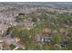 An aerial shot shows a home nestled in a wooded area, surrounded by trees, and other homes in the distance at 7904 Kingsland Dr, Raleigh, NC 27613