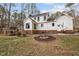 This backyard features a fire pit, a deck with stairs, and a white house exterior with black window trim at 7904 Kingsland Dr, Raleigh, NC 27613