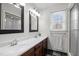 Well-lit bathroom with double sink vanity, framed mirrors, a window and walk-in shower at 7904 Kingsland Dr, Raleigh, NC 27613