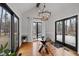 Dining room features a modern chandelier, glass table, and scenic backyard views at 7904 Kingsland Dr, Raleigh, NC 27613