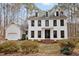 The traditional home features a white exterior with striking black trim and mature landscaping at 7904 Kingsland Dr, Raleigh, NC 27613