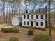 Two-story home with a black roof, dormer windows, and an attached garage with a beautiful lawn at 7904 Kingsland Dr, Raleigh, NC 27613